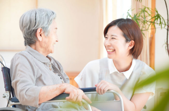 年配の女性と会話する歯科スタッフのイメージ